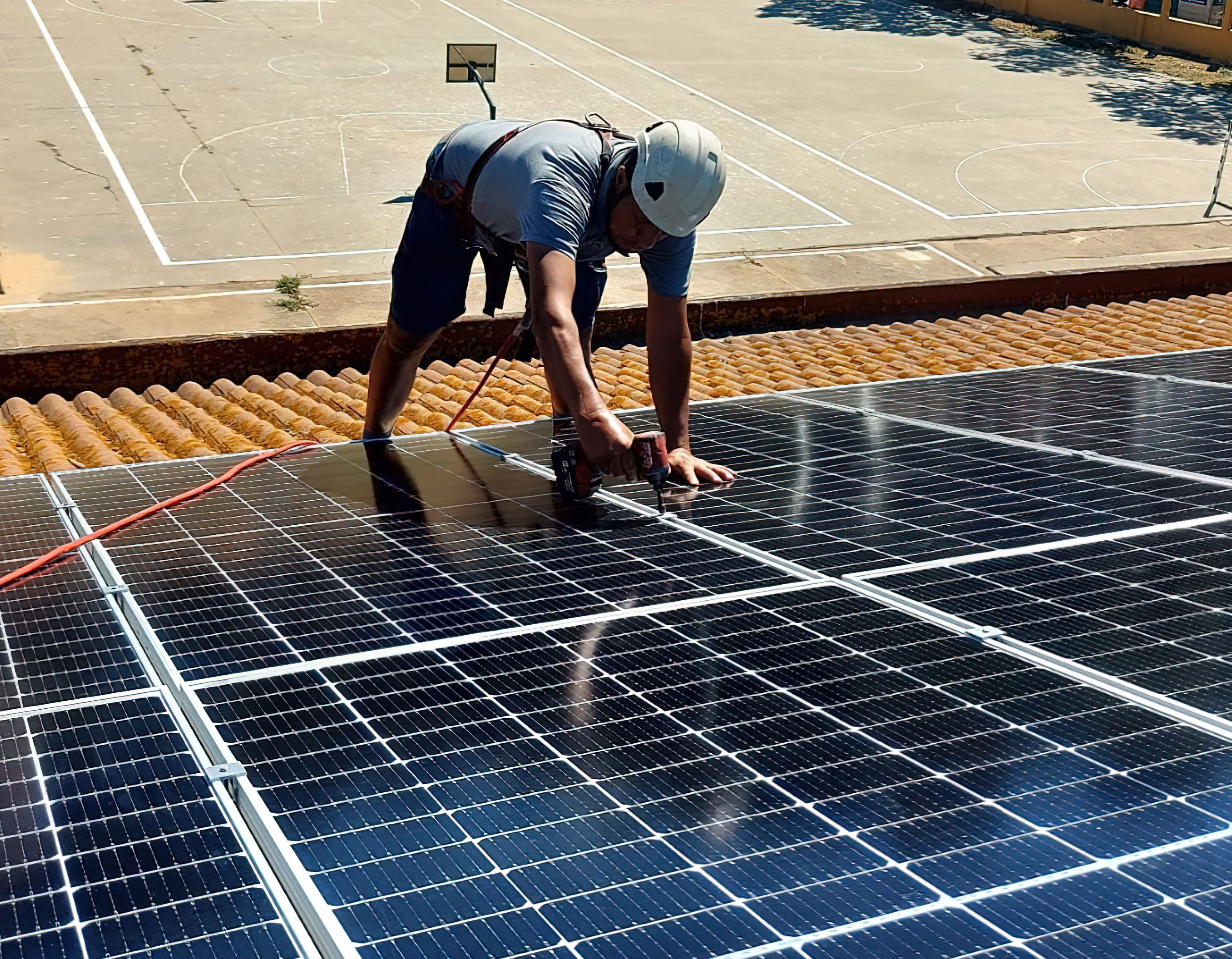 Solia Energías, una empresa para conectar con las oportunidades. Un trabajador instala una placa fotovoltaica en un centro escolar. | Grupo Barberán. 